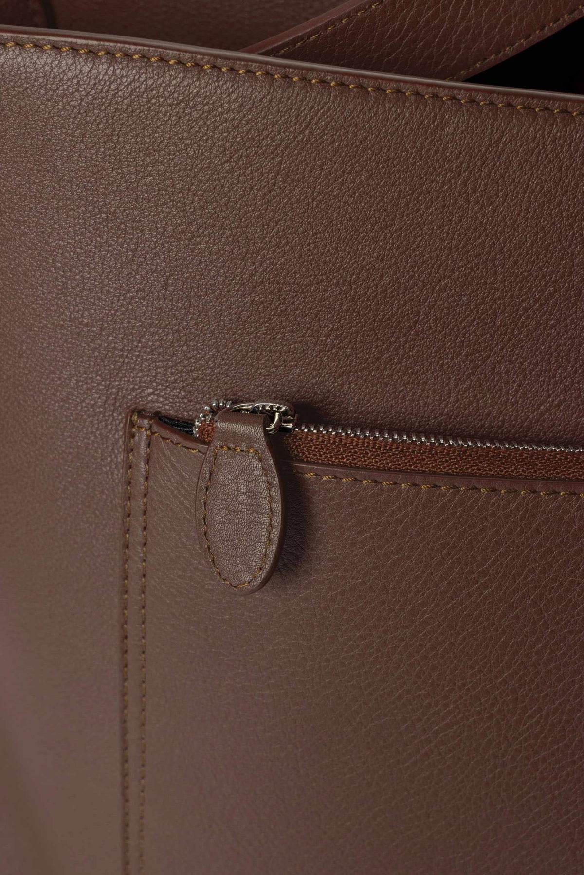 Detail view of the zip closure pocket on The Metro Tote in the color Cordoba.