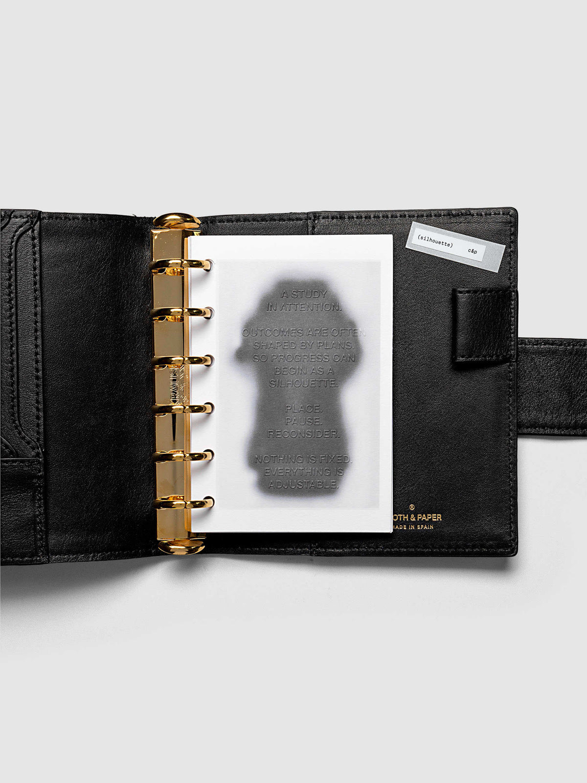 Silhouette Planner Dashboard in Pocket. Greyscale silhouette print with embossed text on paper. Image 2 of 2.