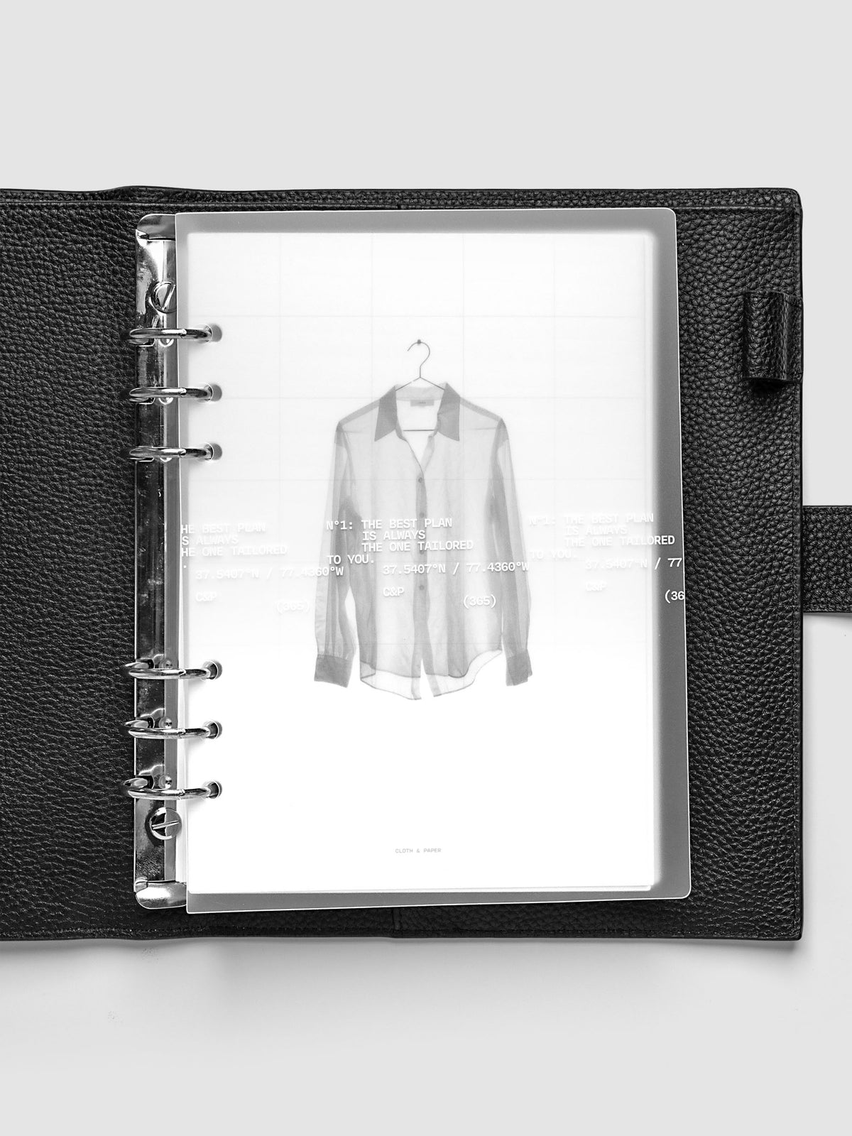 Transparent planner cover set with white printed text design and accompanying black and white dashboard with an image of a tailored shirt on a hanger. Pre-punched for 6-ring planners shown in size A5 inside a black leather agenda.