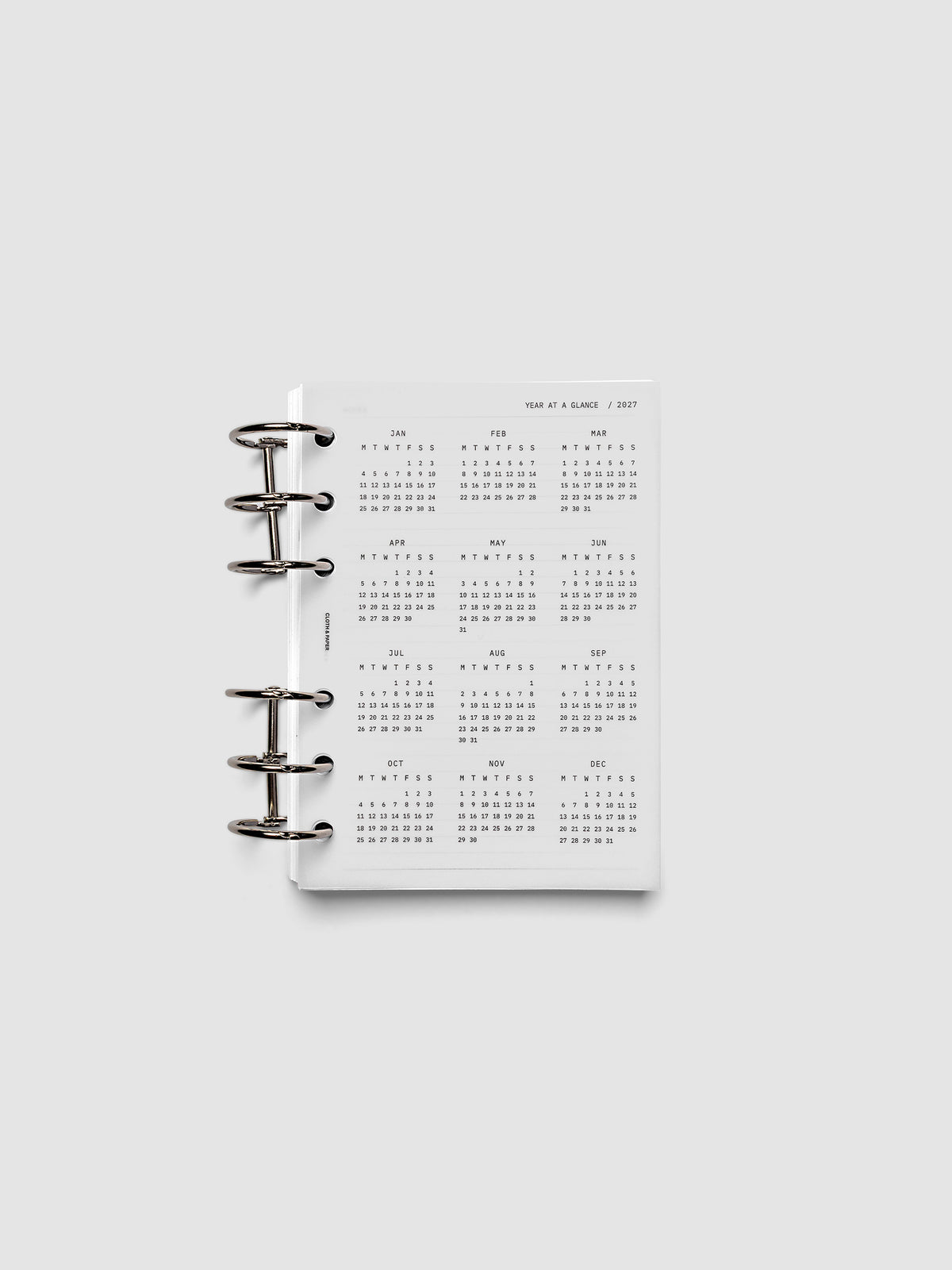 2027 Year At A Glance Dashboard Monday Start, A6 6-Ring Punch, translucent vellum year-at-a-glance calendar shown inside a planner
