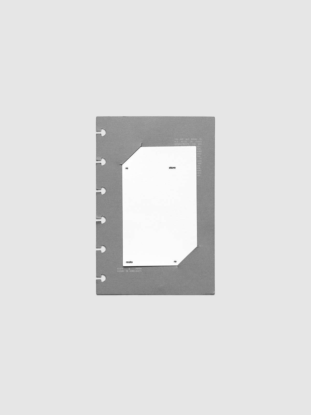 Grey cardstock planner dashboard with white plastic card inserted in slits with white printed text shown in size CP Petite for discbound planners.