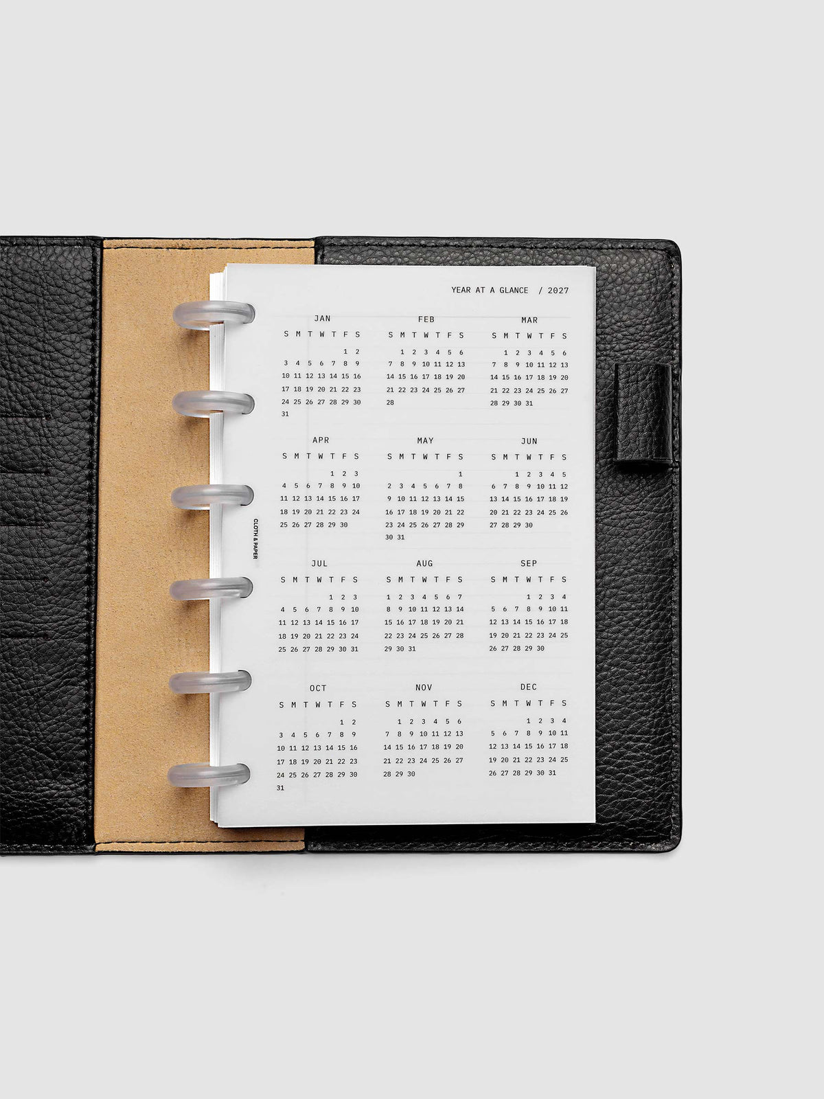2027 Year At A Glance Dashboard Sunday Start, CP Petite 6-Disc Punch, translucent vellum year-at-a-glance calendar shown inside a planner