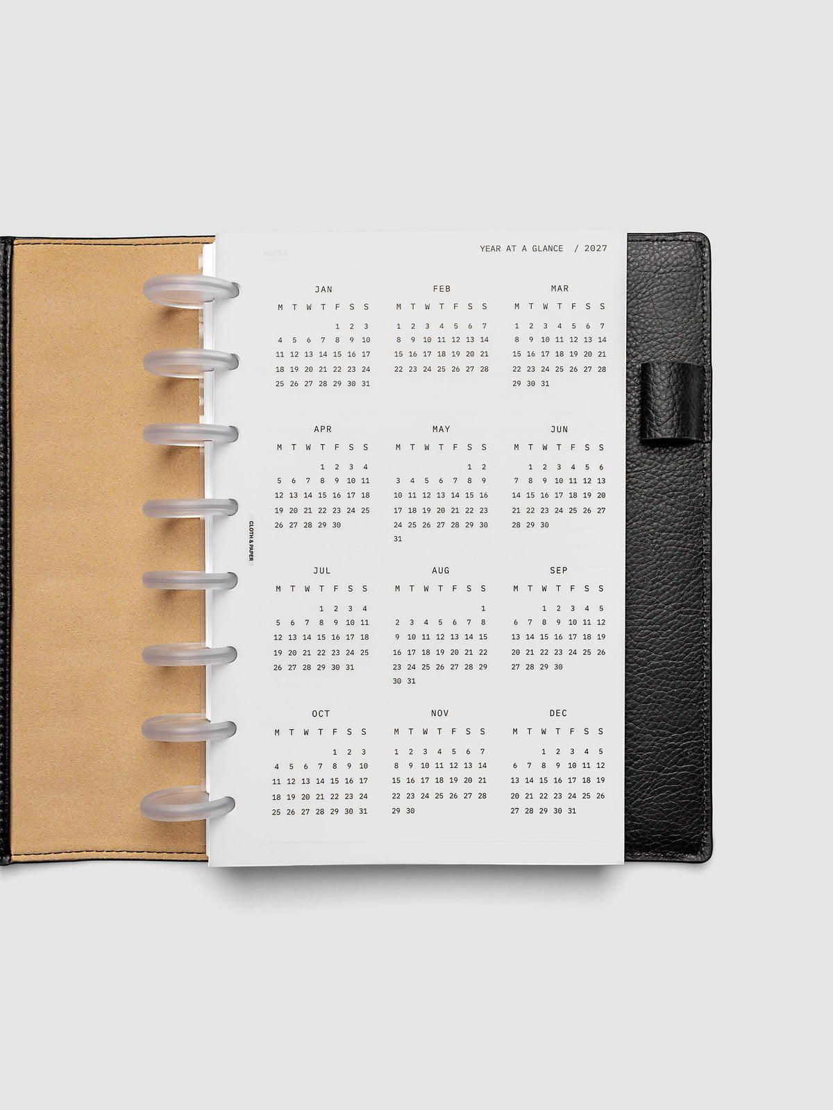 2027 Year At A Glance Dashboard Monday Start, Half Letter 8-Disc Punch, translucent vellum year-at-a-glance calendar shown inside a planner