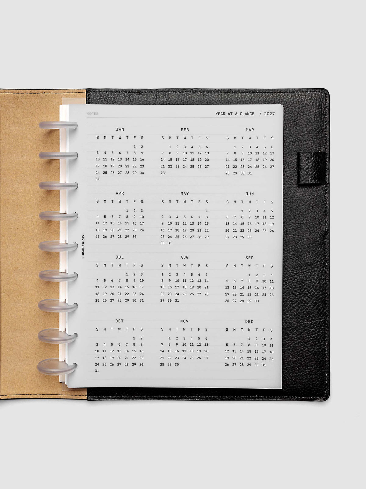 2027 Year At A Glance Dashboard Sunday Start, HP Classic 9-Disc Punch, translucent vellum year-at-a-glance calendar shown inside a planner