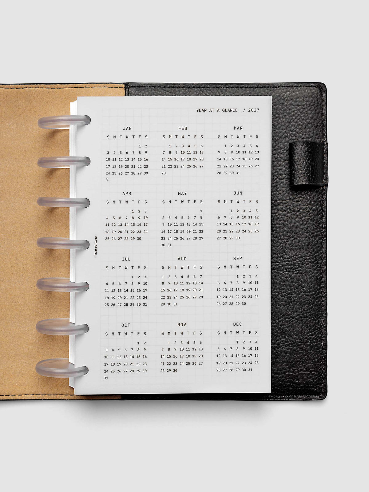 2027 Year At A Glance Dashboard Sunday Start, HP Mini 7-Disc Punch, translucent vellum year-at-a-glance calendar shown inside a planner