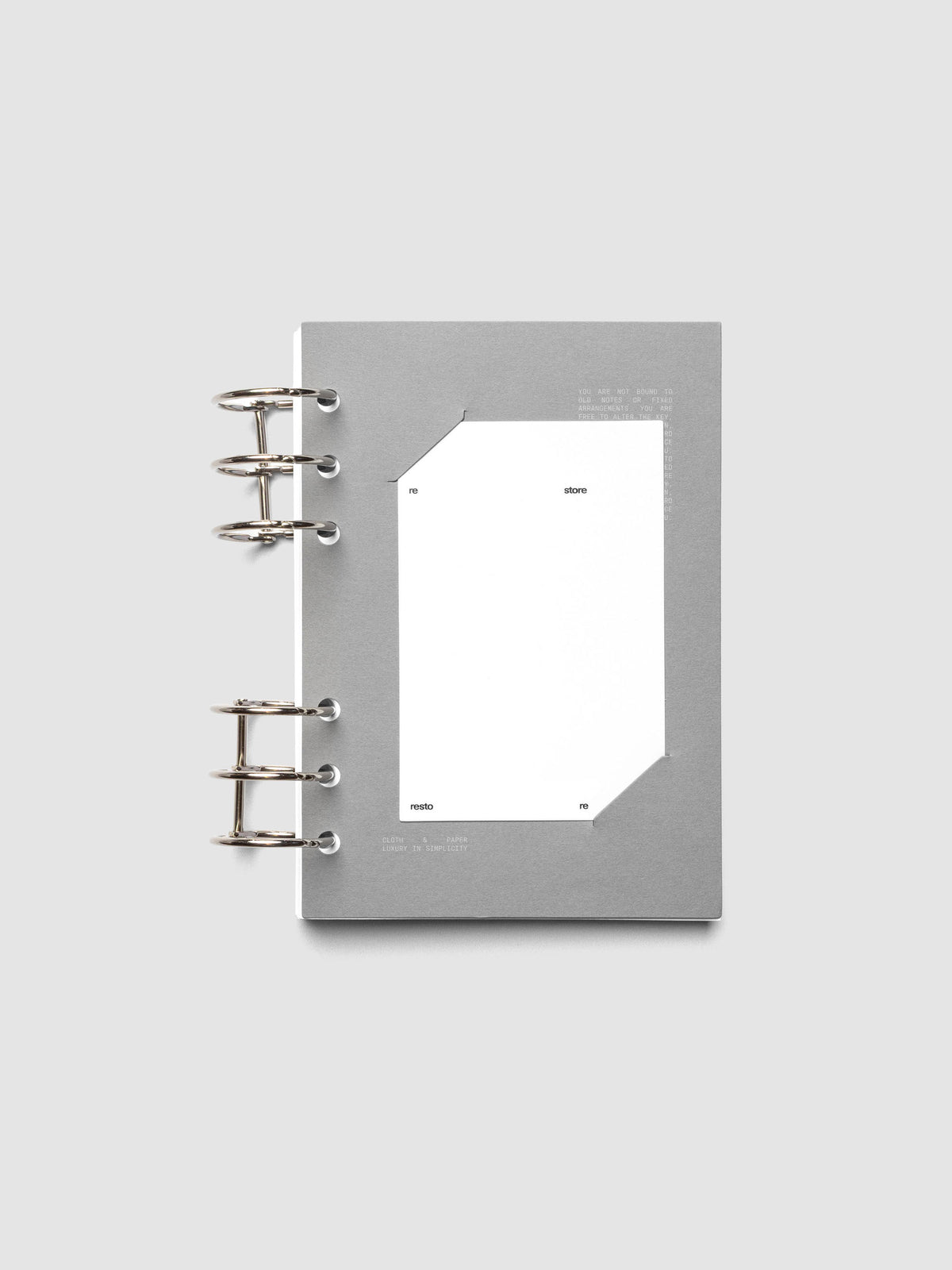 Grey cardstock planner dashboard with white plastic card inserted in slits with white printed text shown in size Personal Wide shown in a ring bound planner.