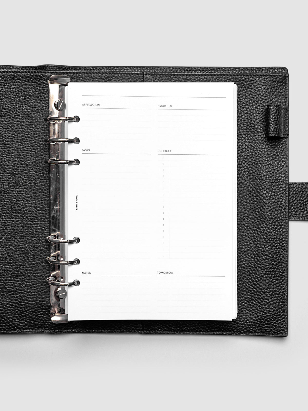 Daily Essentials Planner Inserts shown in size A5 inside a black agenda.
