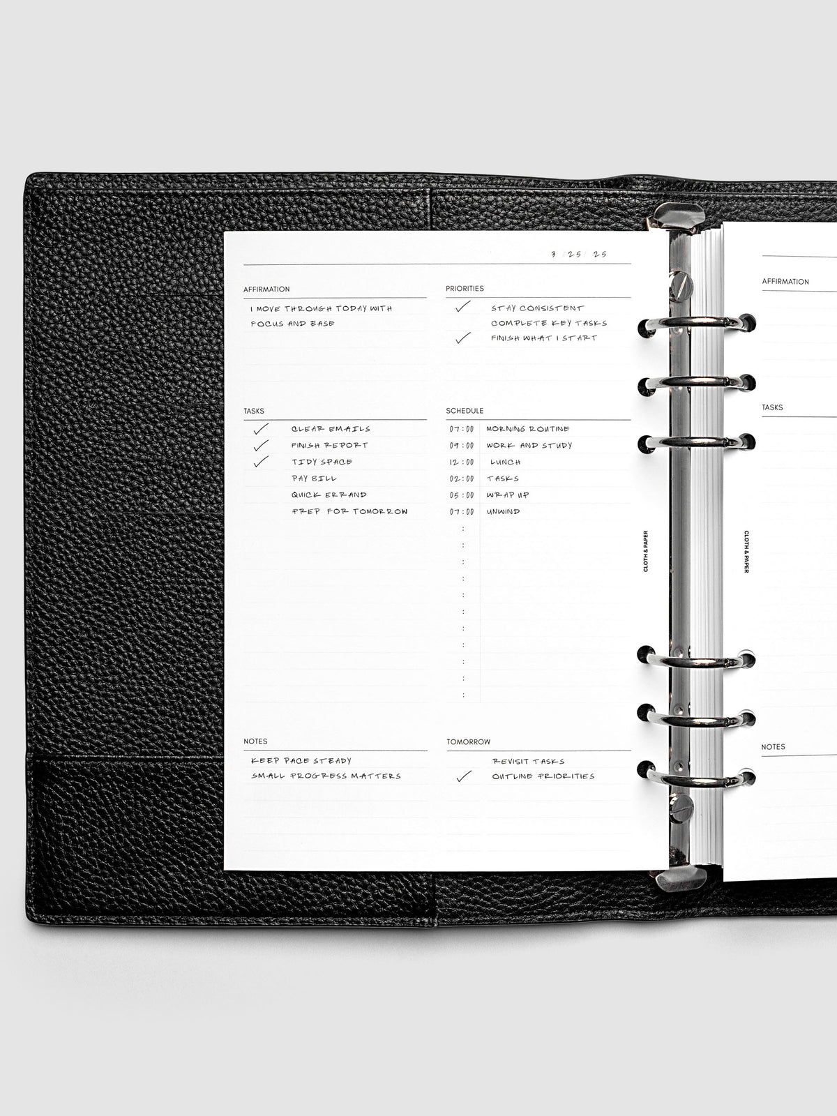 Demo page for the Daily Essentials Planner Inserts shown in size A5 inside a black agenda.