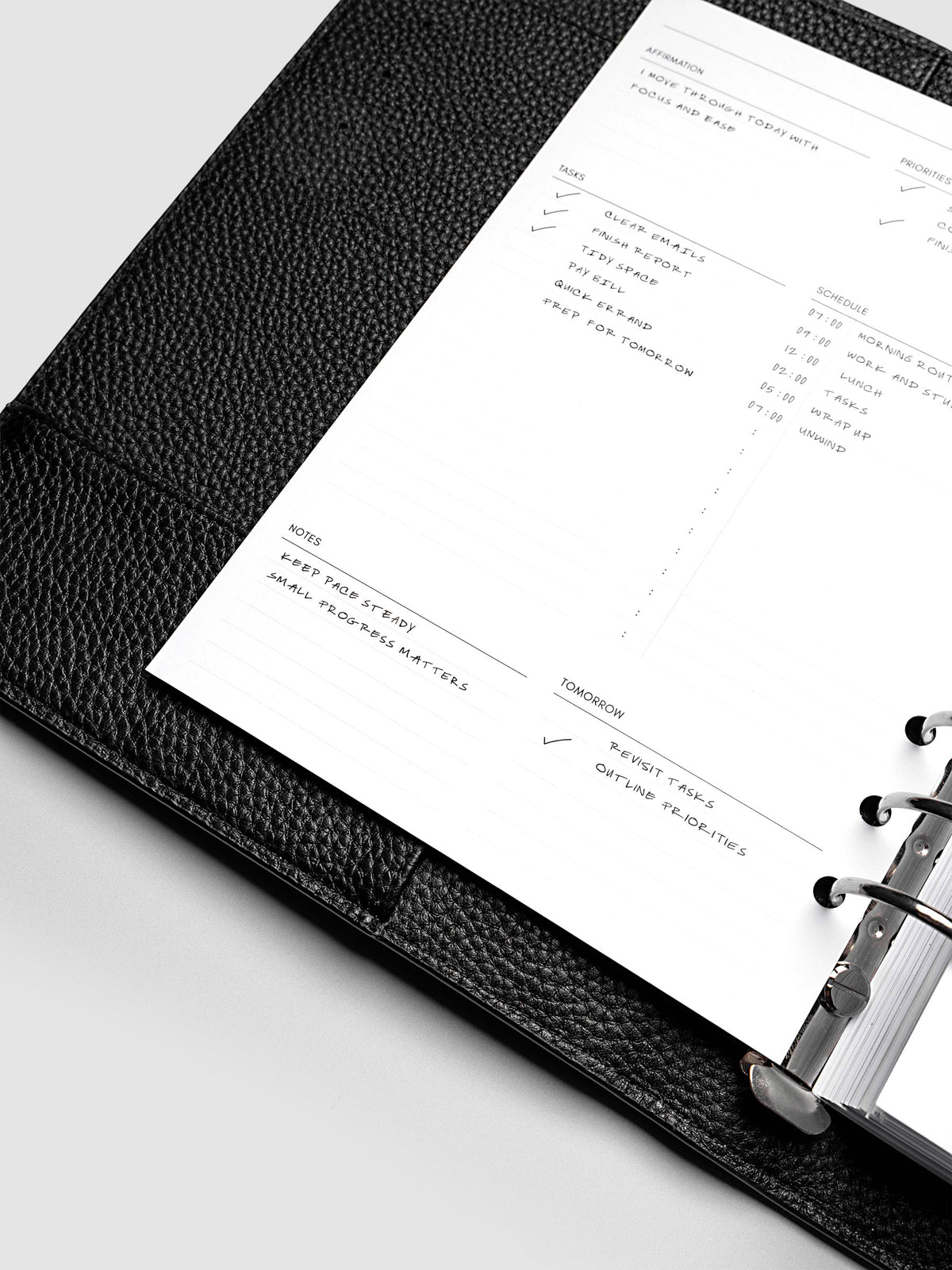 Close up of the demo page for the Daily Essentials Planner insert inside an A5 black agenda.
