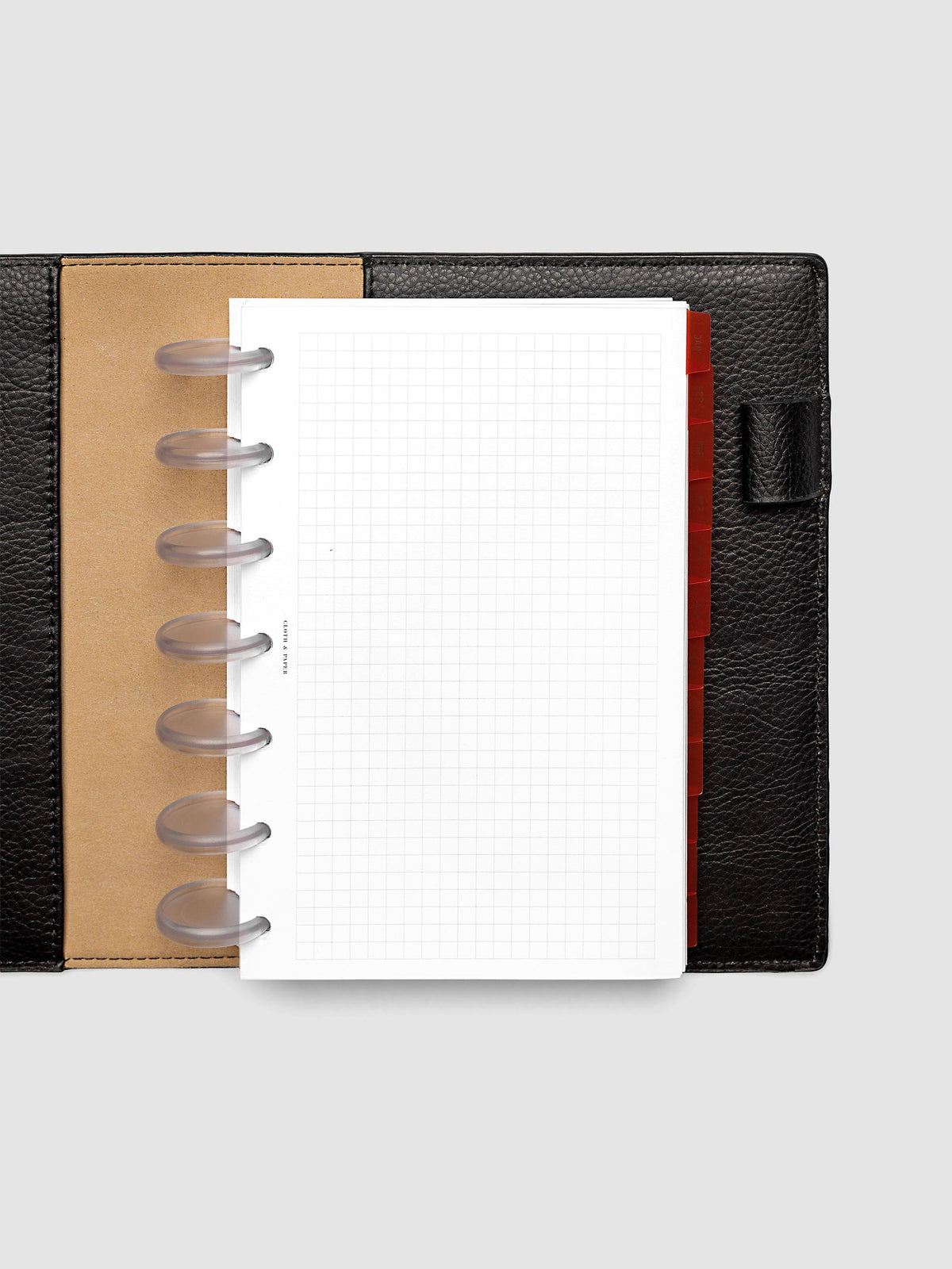 HP Mini 7-Disc Punch Ultra-Thin Monthly Dividers in deep orange shown tabbed inside a planner