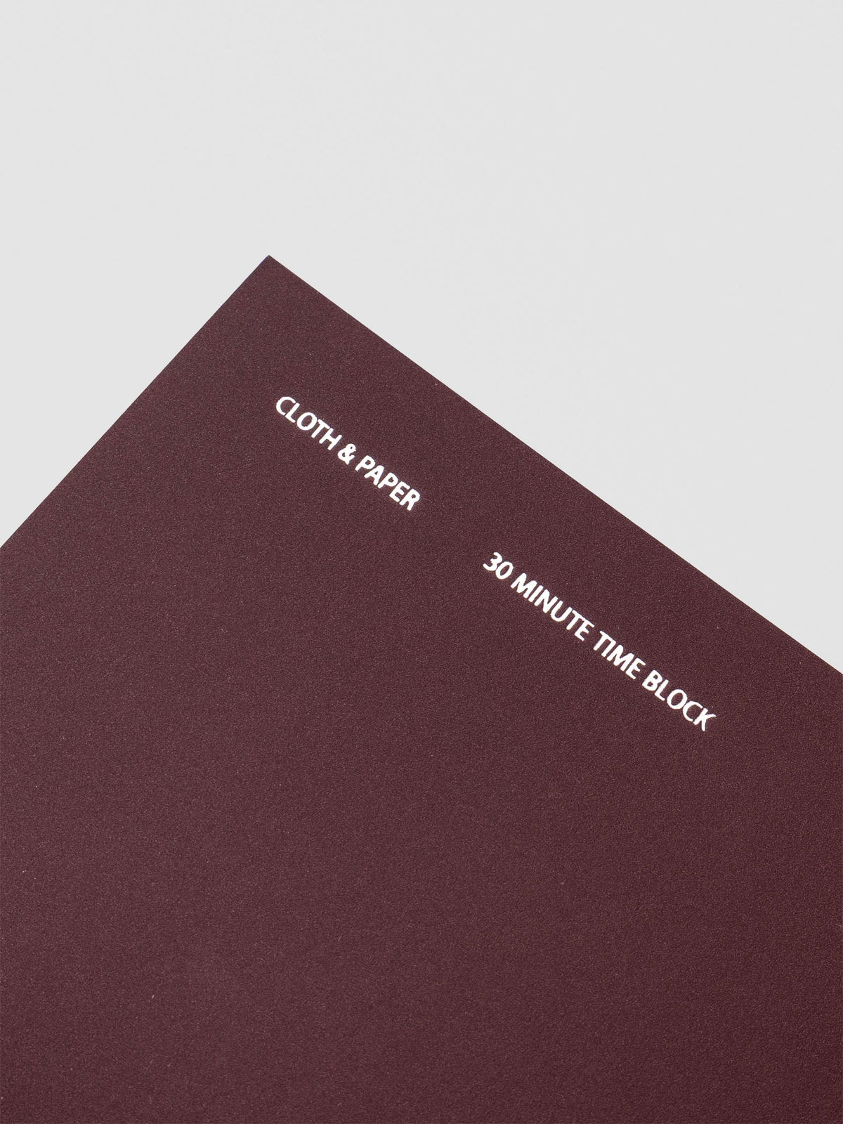 Travel Notebook in size A5 Slim in color Bordeaux with 30 Minute Time Block pages shown from the front as a close up.