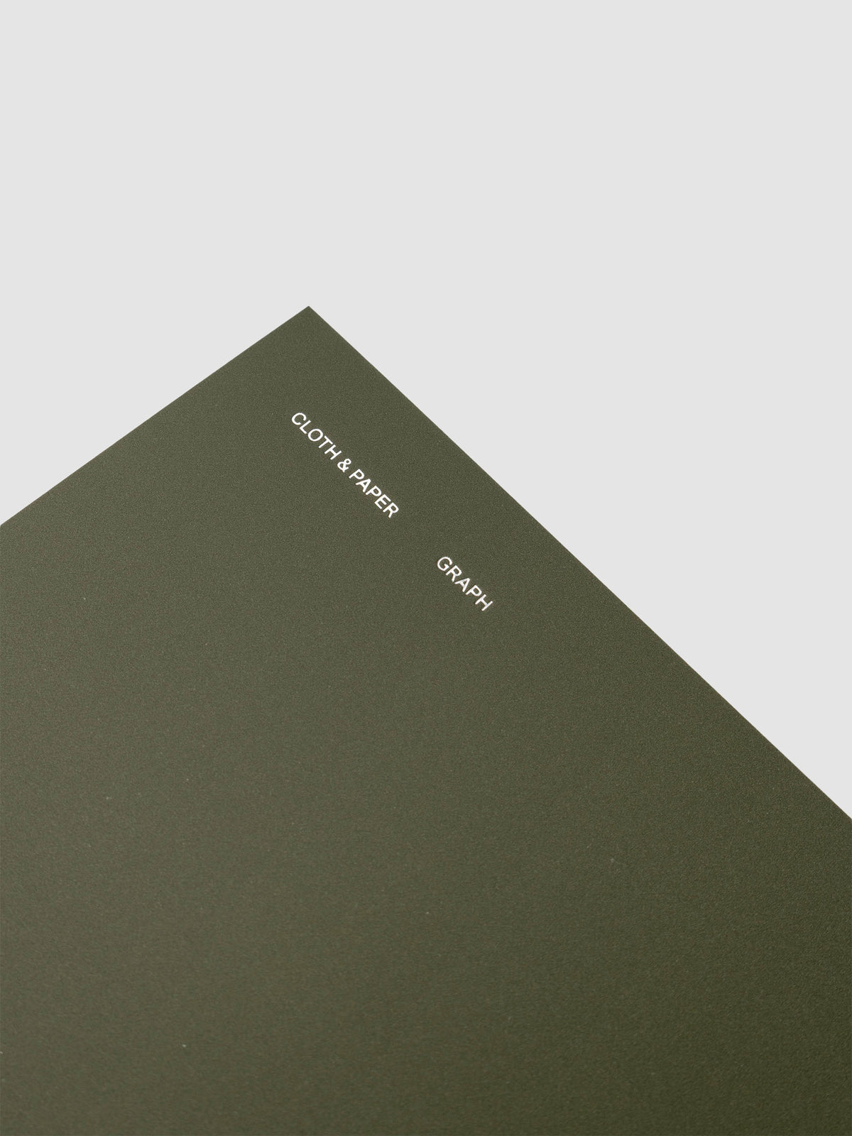 Spiral Notebook in size A5 and color Olive green with graph note interior pages showing a close up of the silver foil details on the soft touch cover.