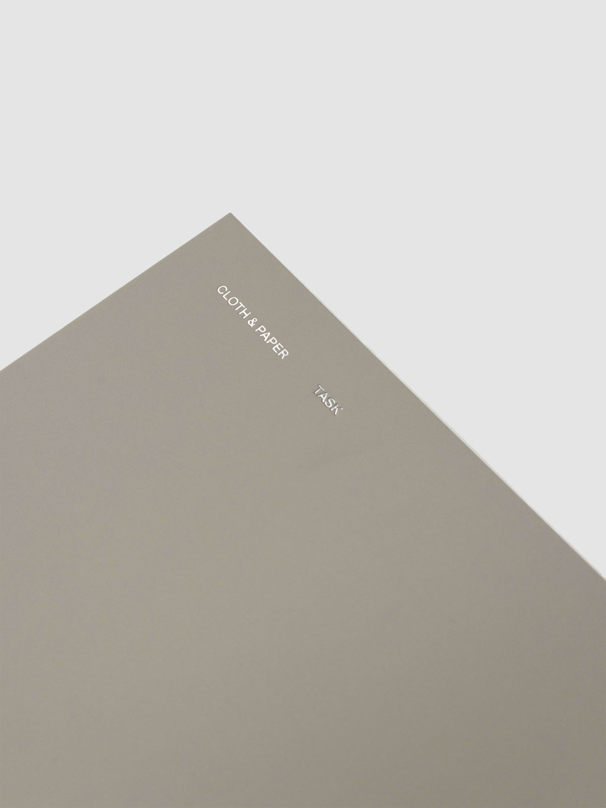 Spiral Notebook in size A5 and color Ristretto beige with Task interior pages shown close up displaying foil details on soft touch cover.