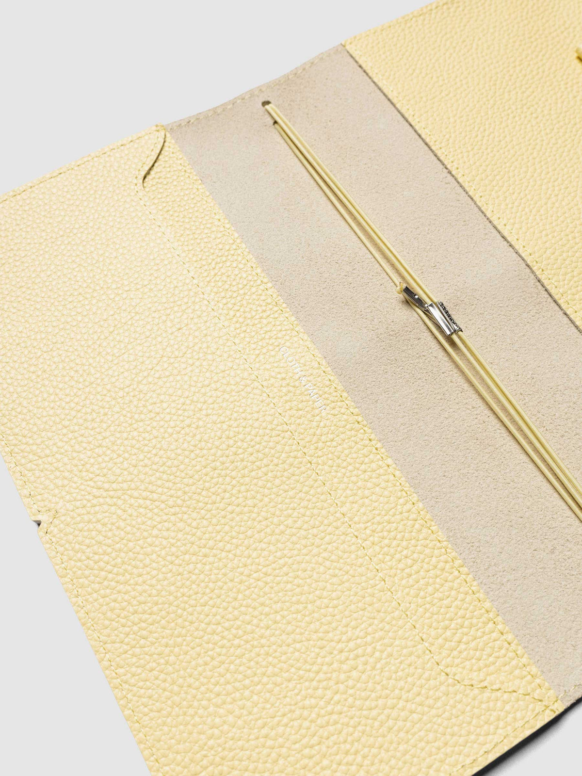 Butter yellow leather travel notebook cover in size A5 Slim shown open with interior pockes and elastic bands.