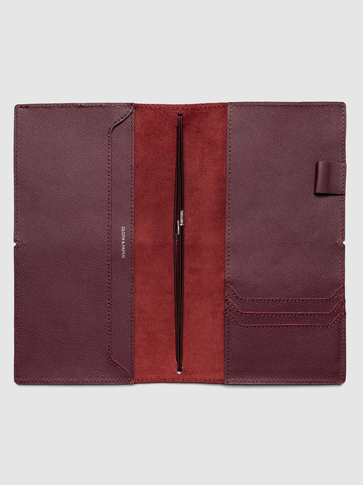 Deep red leather travel notebook cover in size A5 Slim shown open with interior pockes and elastic bands.