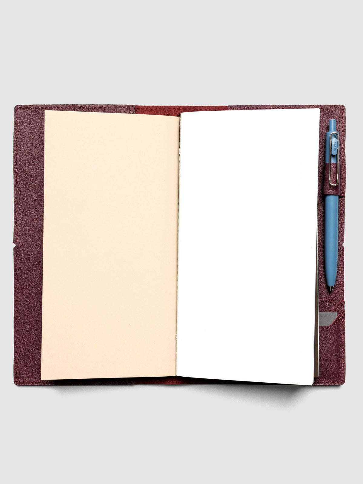 Deep red leather travel notebook cover in size A5 Slim shown with travel notebooks inside.