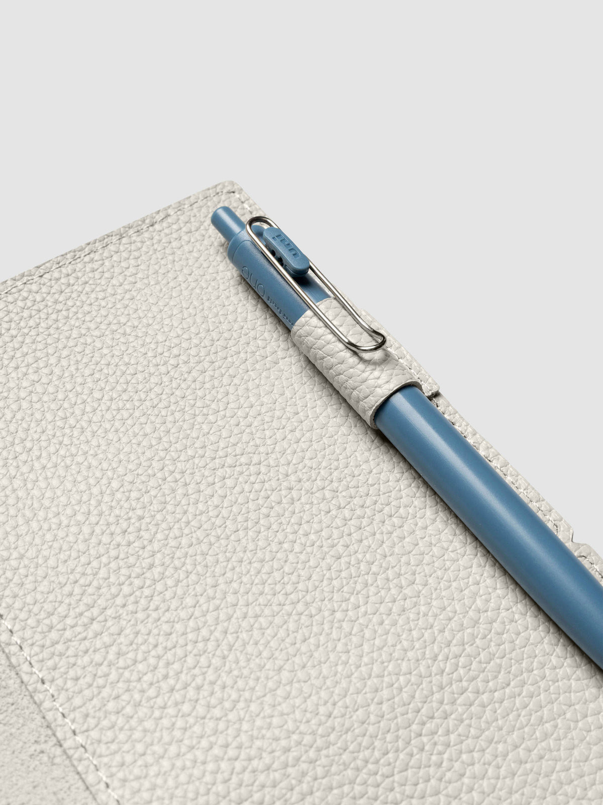 Light grey leather travel notebook cover in size A5 Slim shown open with a pen in the pen loop.