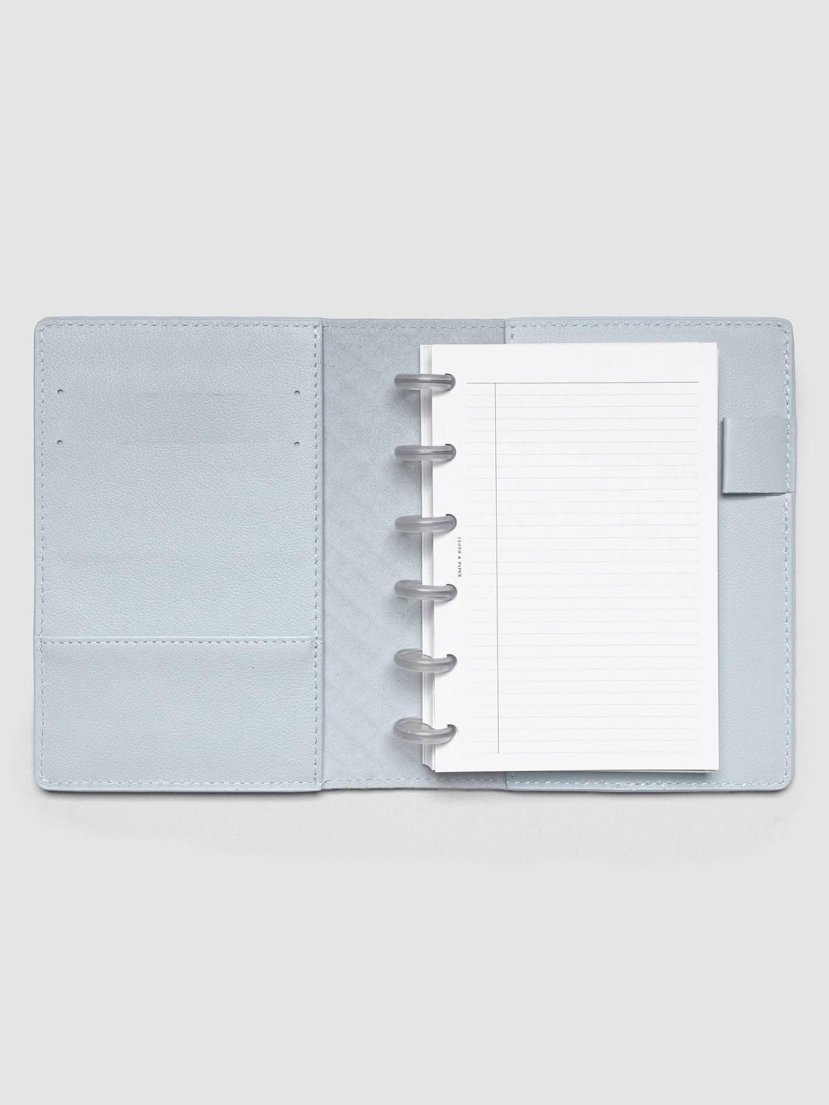 Open blue leather planner folio with a CP petite discbound planner inside.