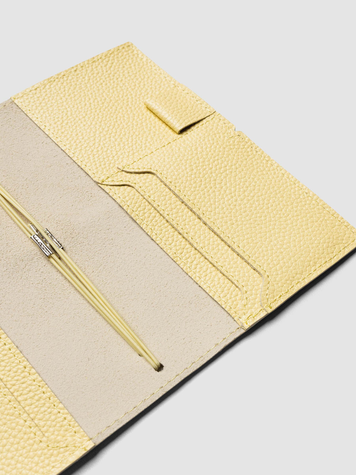 Butter yellow leather travel notebook cover in size Pocket Plus shown open with interior pockes and elastic bands.