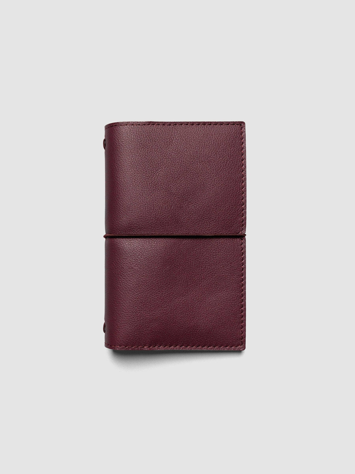 Deep red genuine leather travel notebook cover shown in size Pocket Plus.