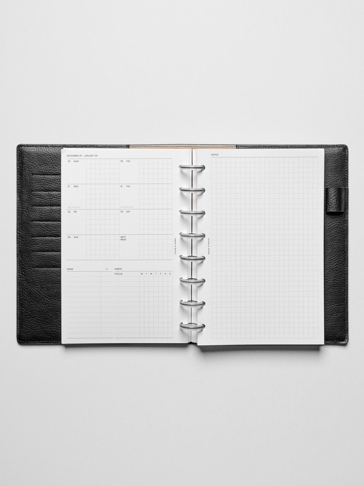 Image shows the Monday Start 2026 Dated Weekly Admin Planner Insert in a black leather disc-bound planner.