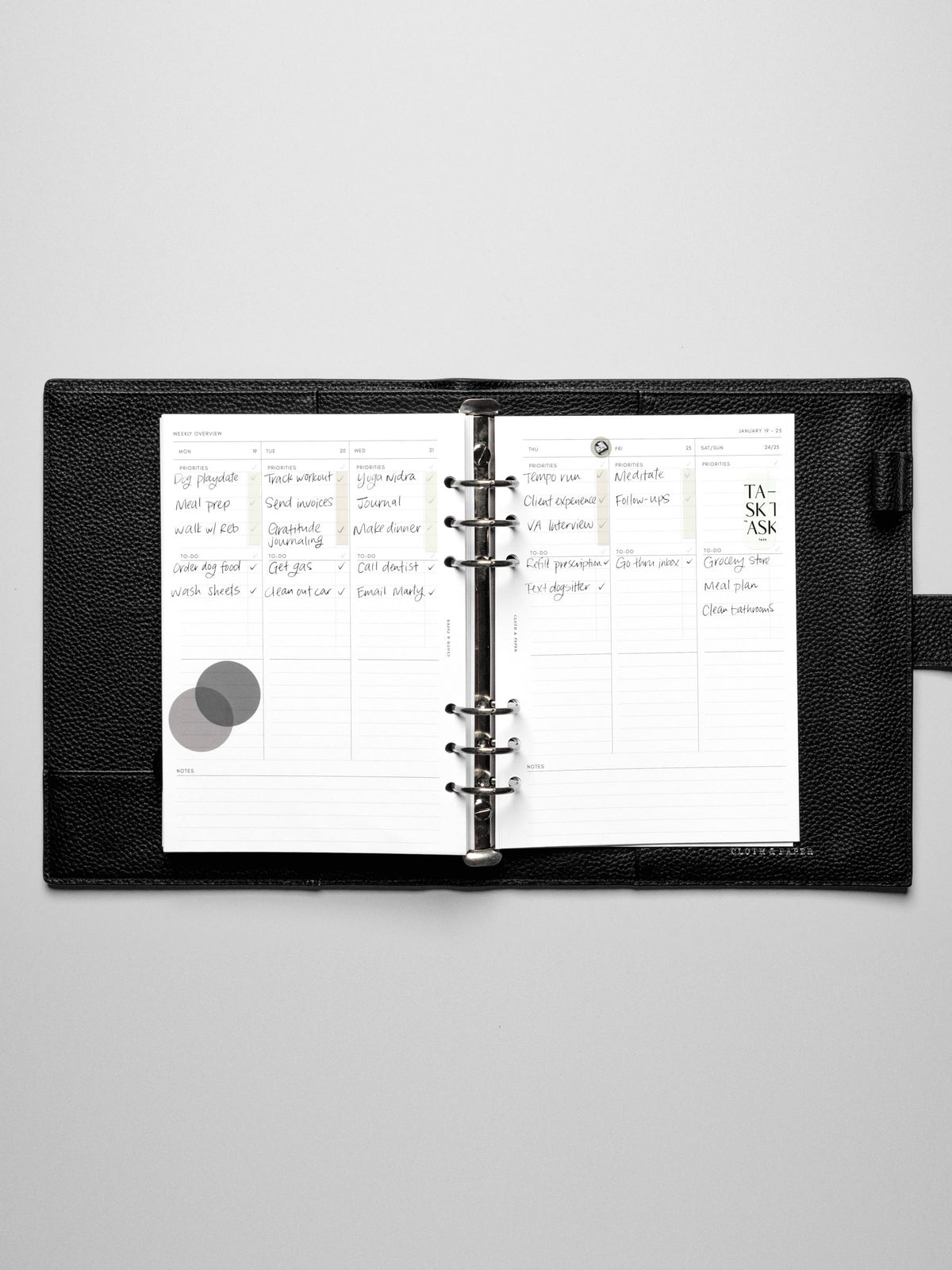The Monday Start 2026 Dated Weekly Task Planner Insert in a black leather ring-bound notebook.