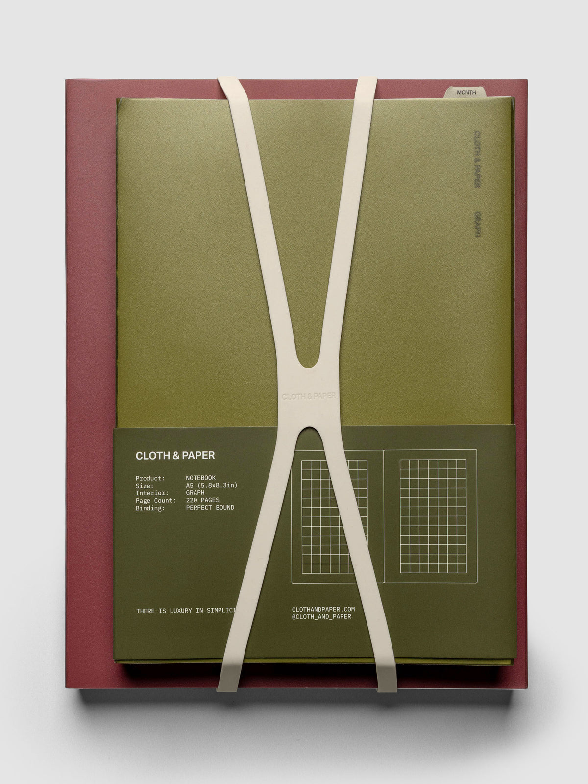 Large, beige planner closure band shown holding an A5 perfect bound notebook on top of an HP Classic perfect bound notebook.