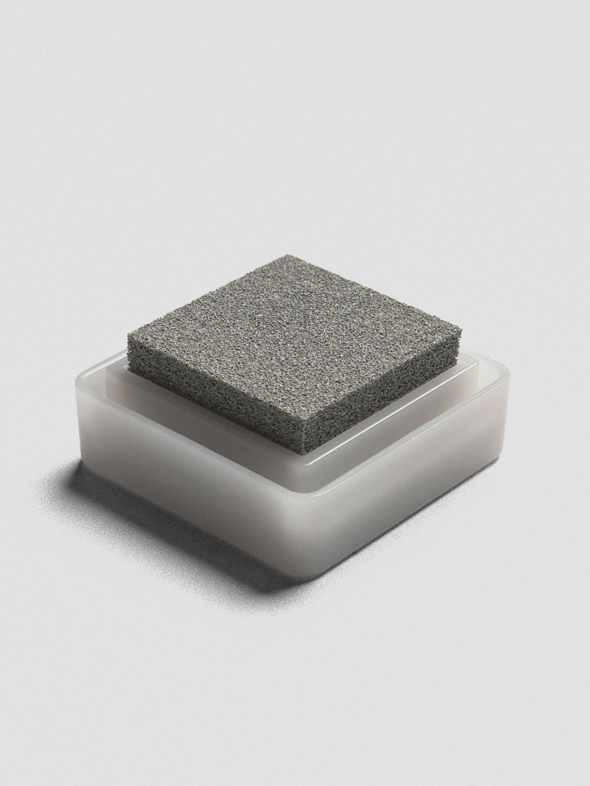 Gray Artnic ink pad without lid, angled view of textured ink surface and white base.