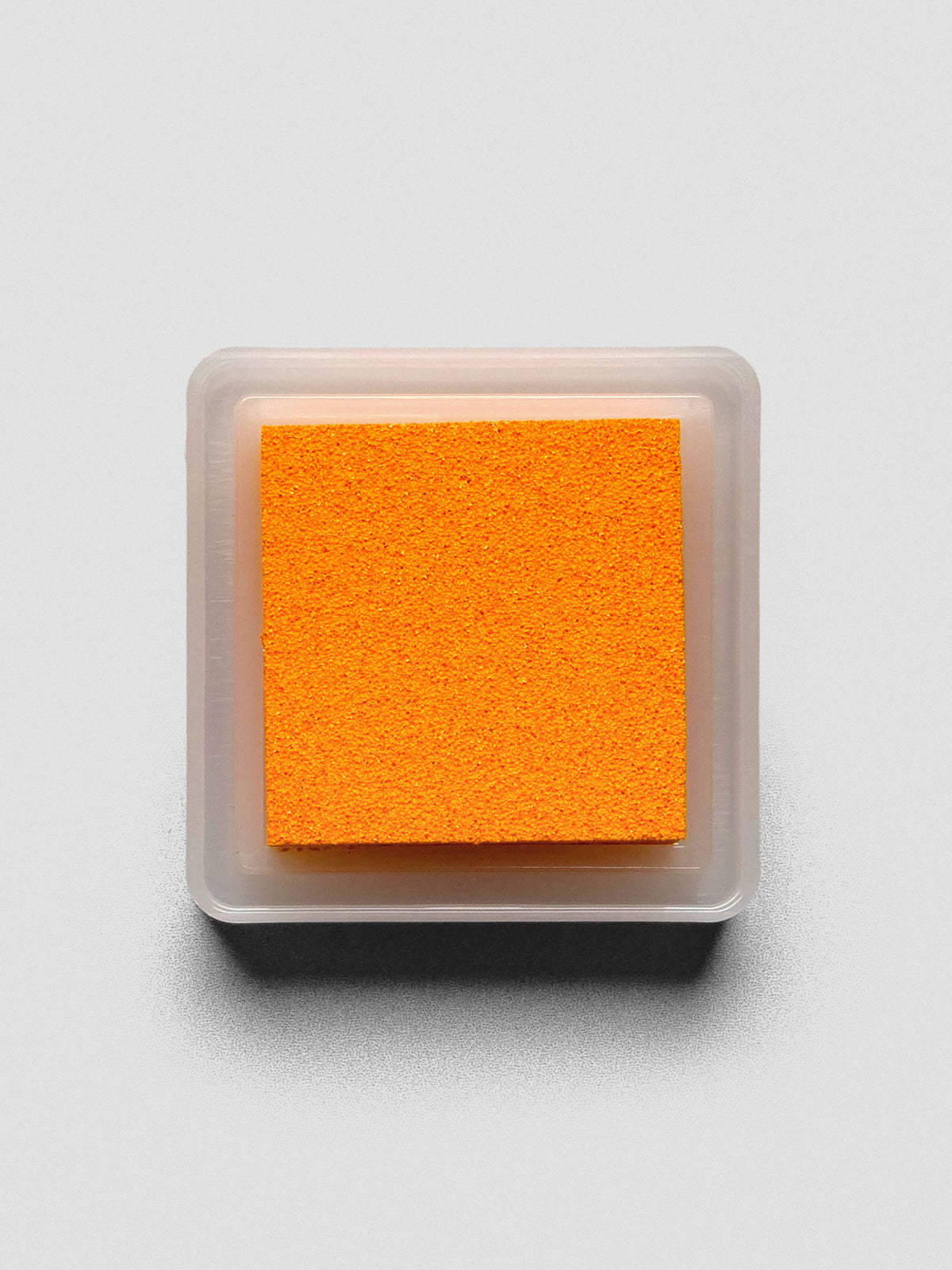Top-down view of open Marigold ink pad showing textured bright orange surface.