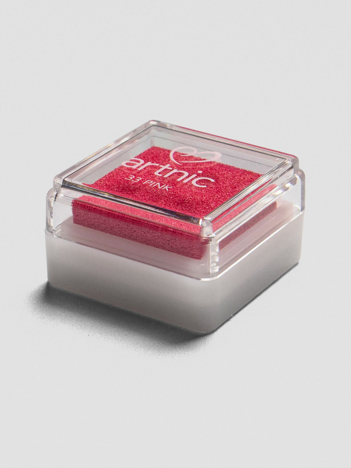 Pink Artnic ink pad with clear lid, angled view showing its stackable design.