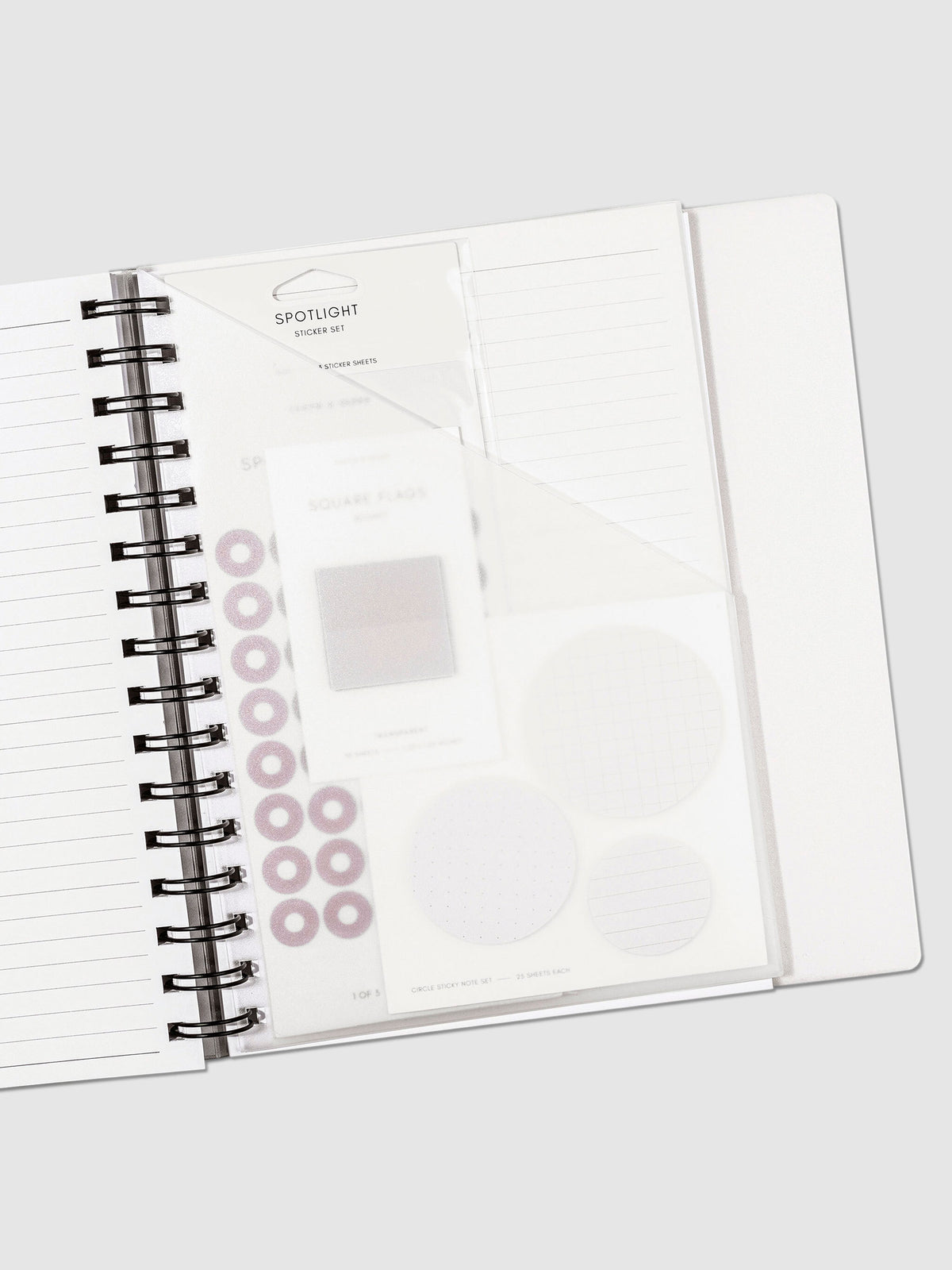 A5 Spiral folder in use inside a lined notebook, with accessories in the folder pocket