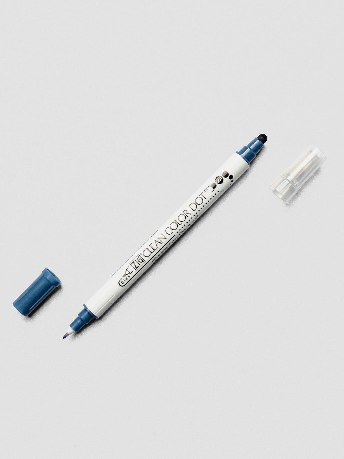 Kuretake ZIG Clean Color Dot Dual Tip Marker in Denim with both caps removed, showcasing the twin-tip design on a light surface.