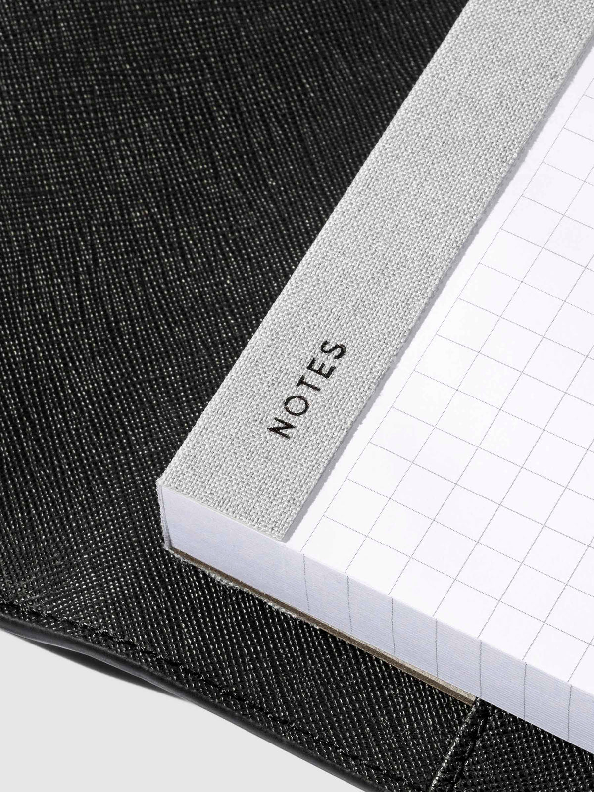 Closeup of "Notes" text printed into the fabric spine of the notepad.