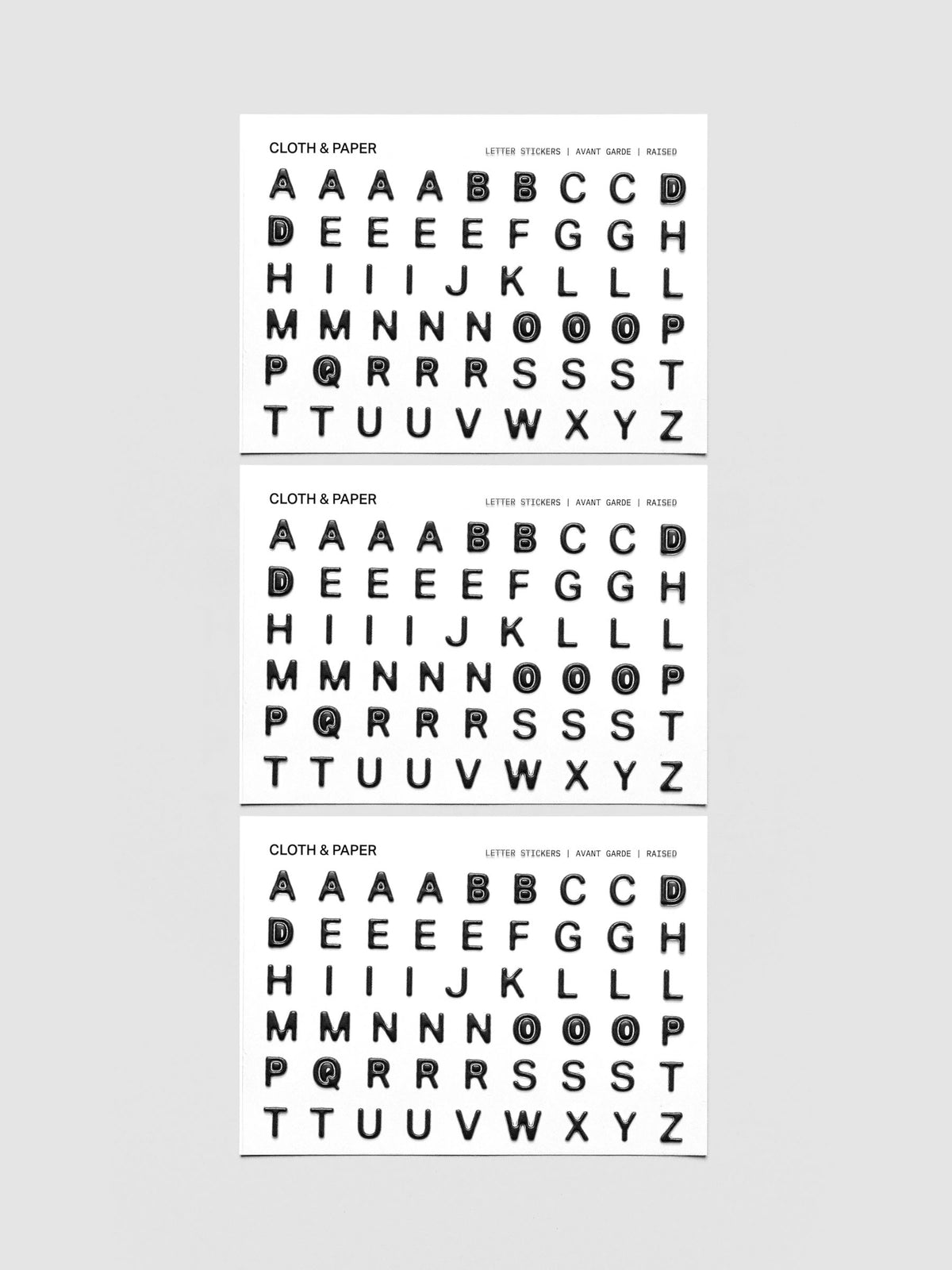 Three sheets of black raised letter stickers.
