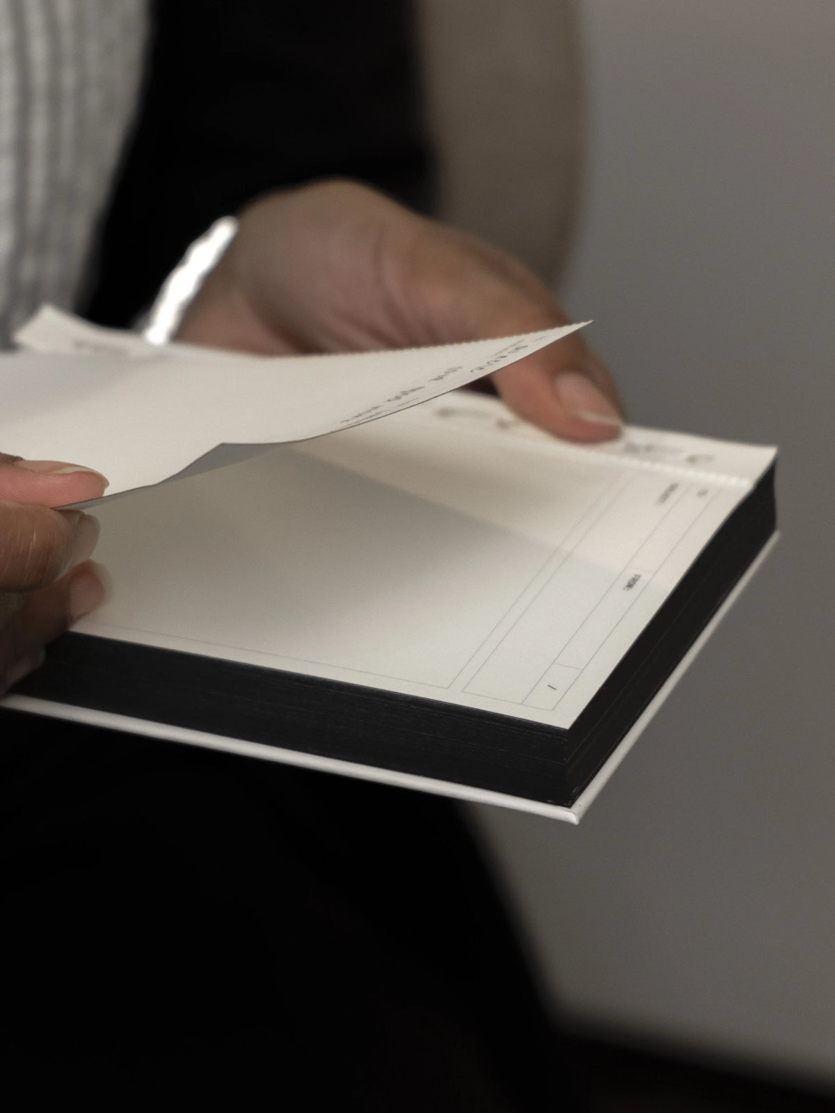 Hands tearing a sheet off the Message Pad.