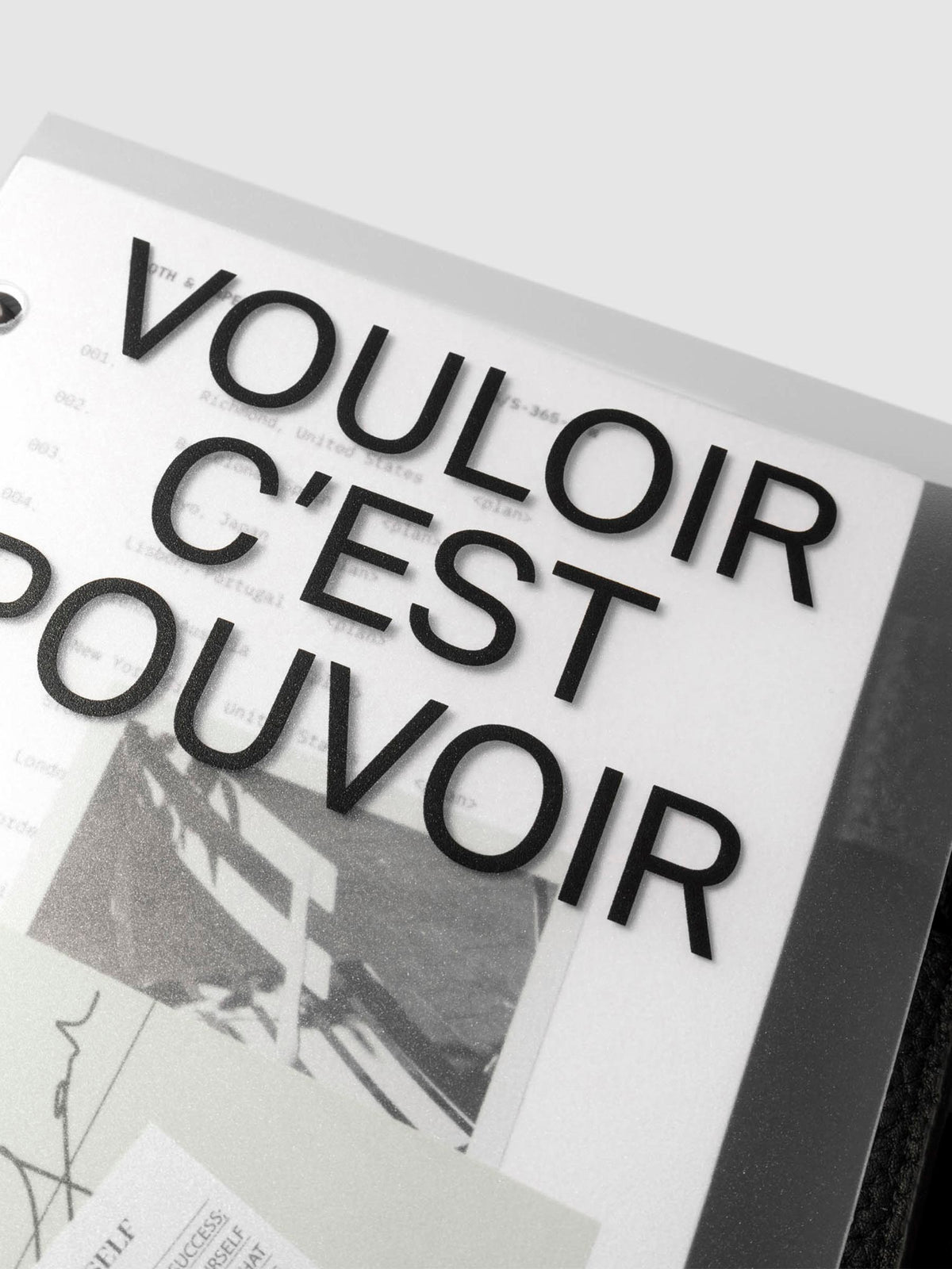 Close up image of the top half of the Moments Cover and Dashboard displayed in black agenda with silver rings. The text reads Vouloir C'est Pouvoir. It is turned at a slight angle on a neutral background.