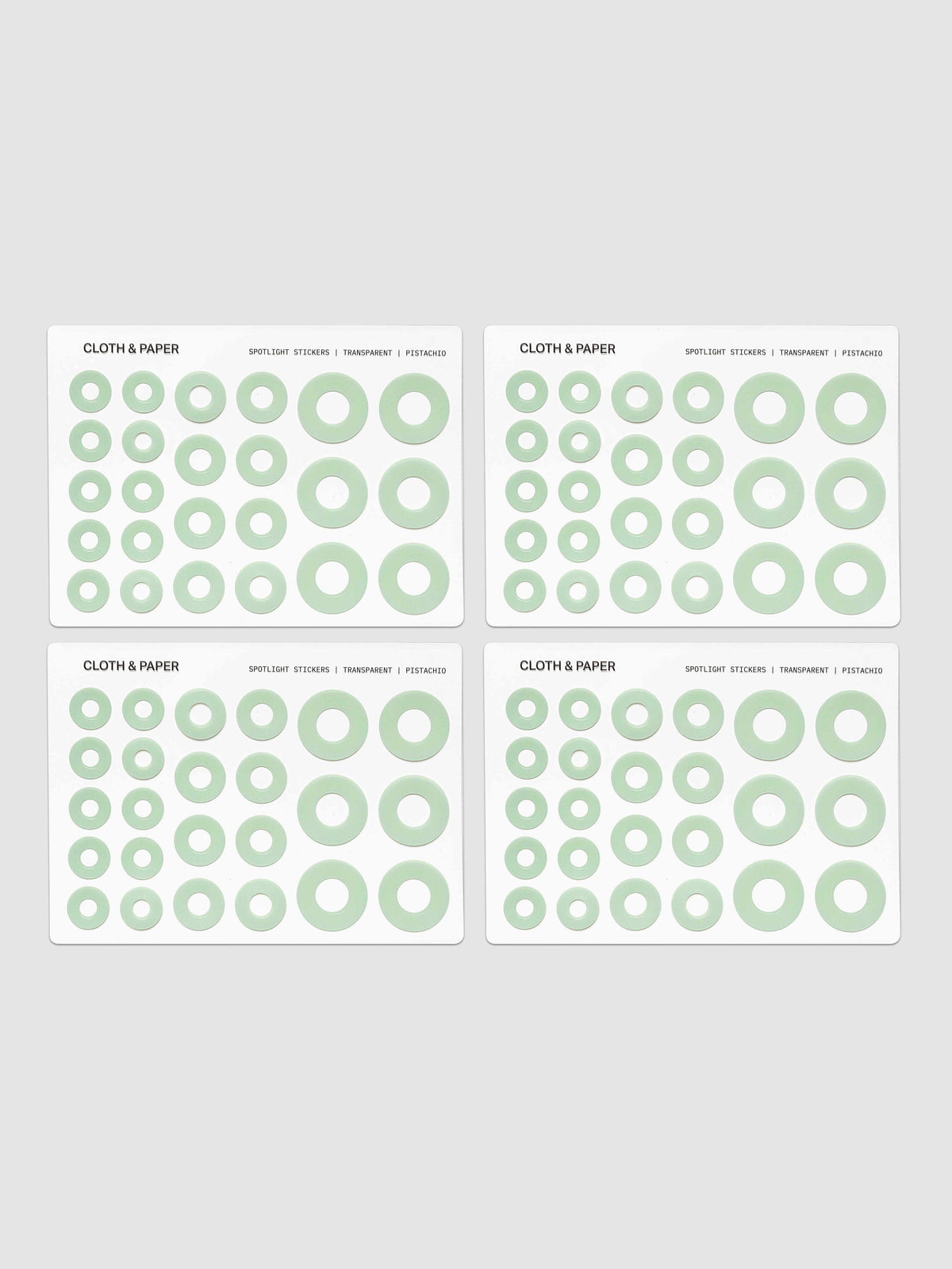 Four sheets of circular stickers of various sizes in light green, arranged on a light gray background.
