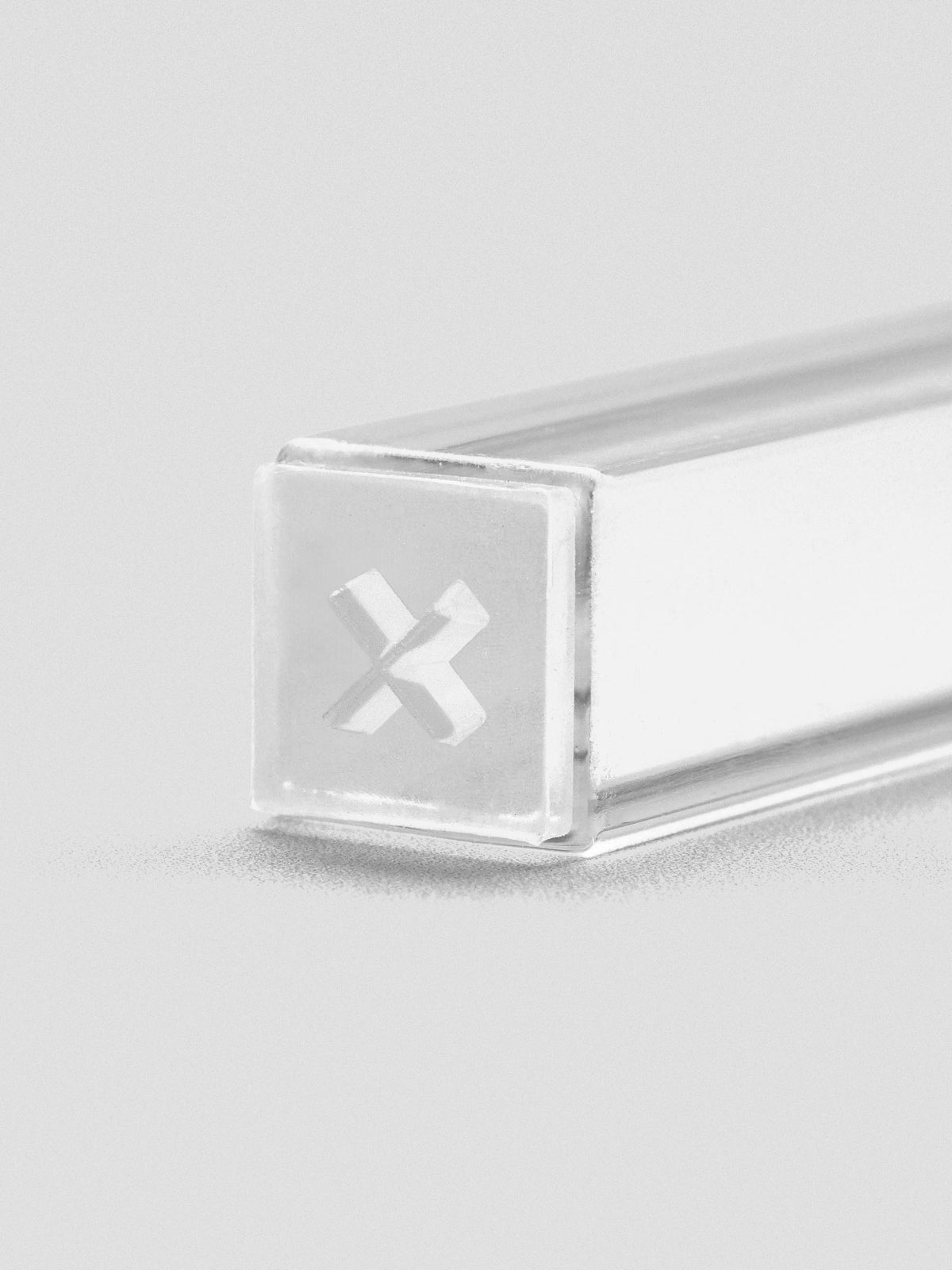 Close-up of stamp stick end with an engraved “X” icon.