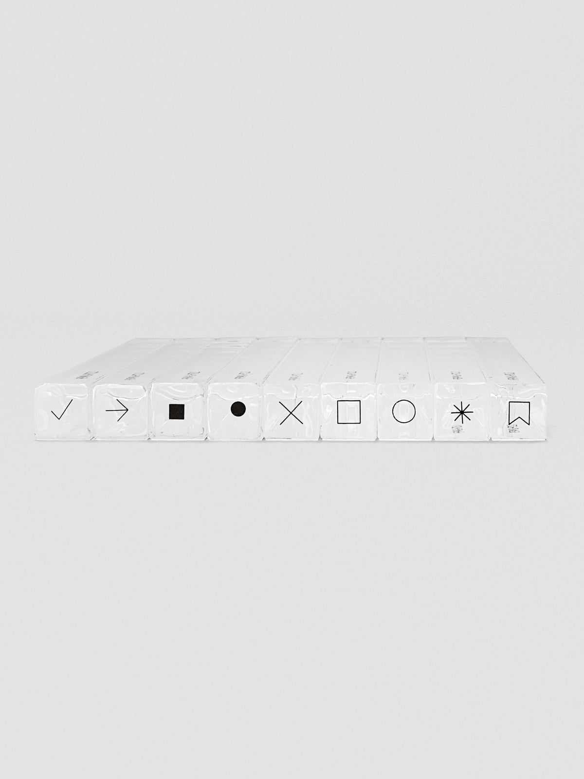 Nine stamp sticks lined up side-by-side with black icons on top, showing different shapes and symbols.