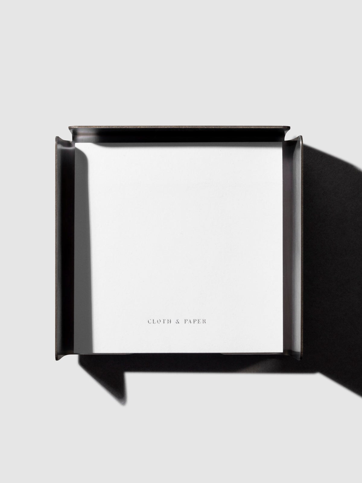Sticky note holder displayed on a neutral background with sticky note placed inside.