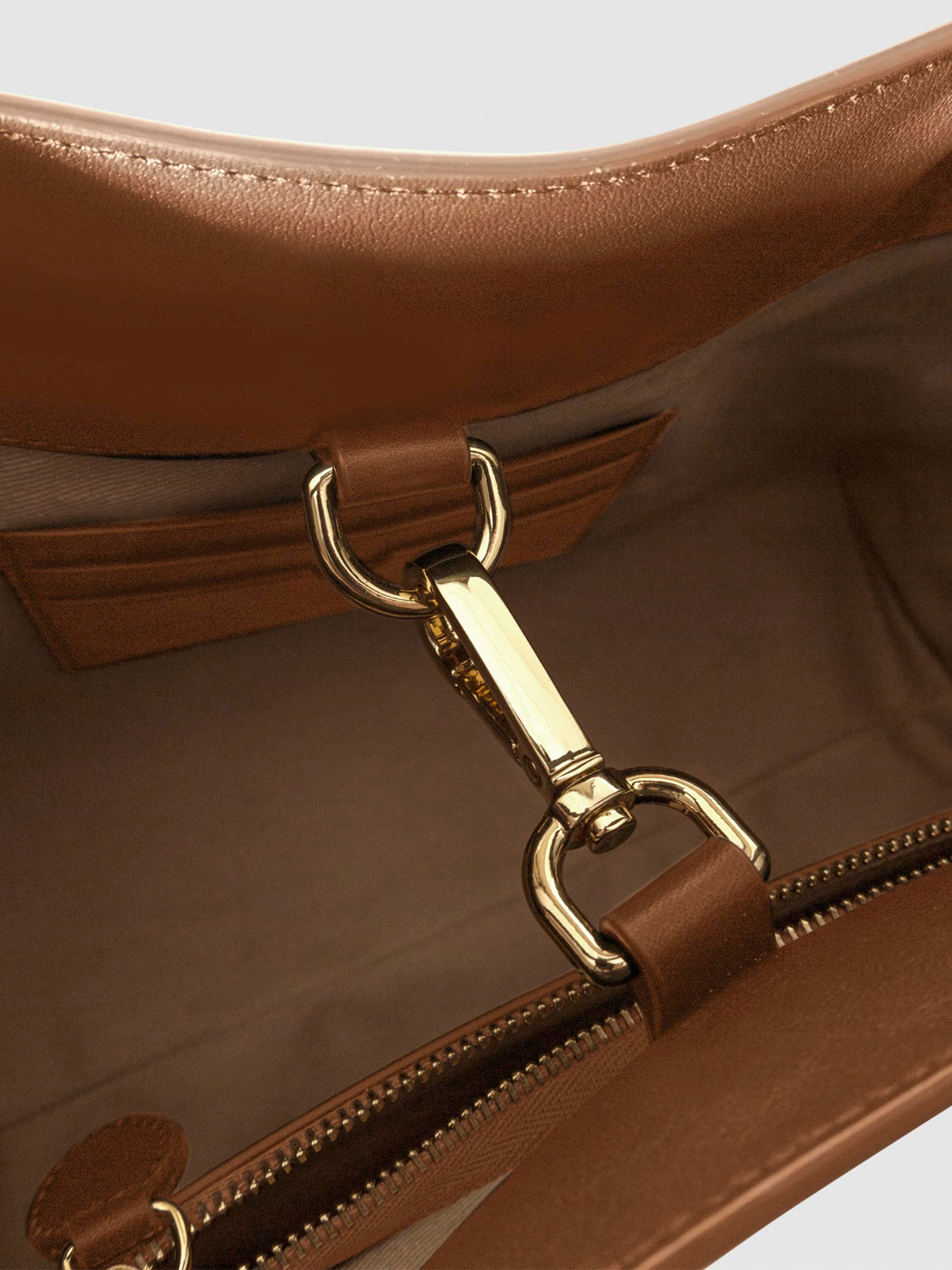 Top down view of bag showcasing its gold hardware. It secures the bag shut. Color shown is Alhambra.
