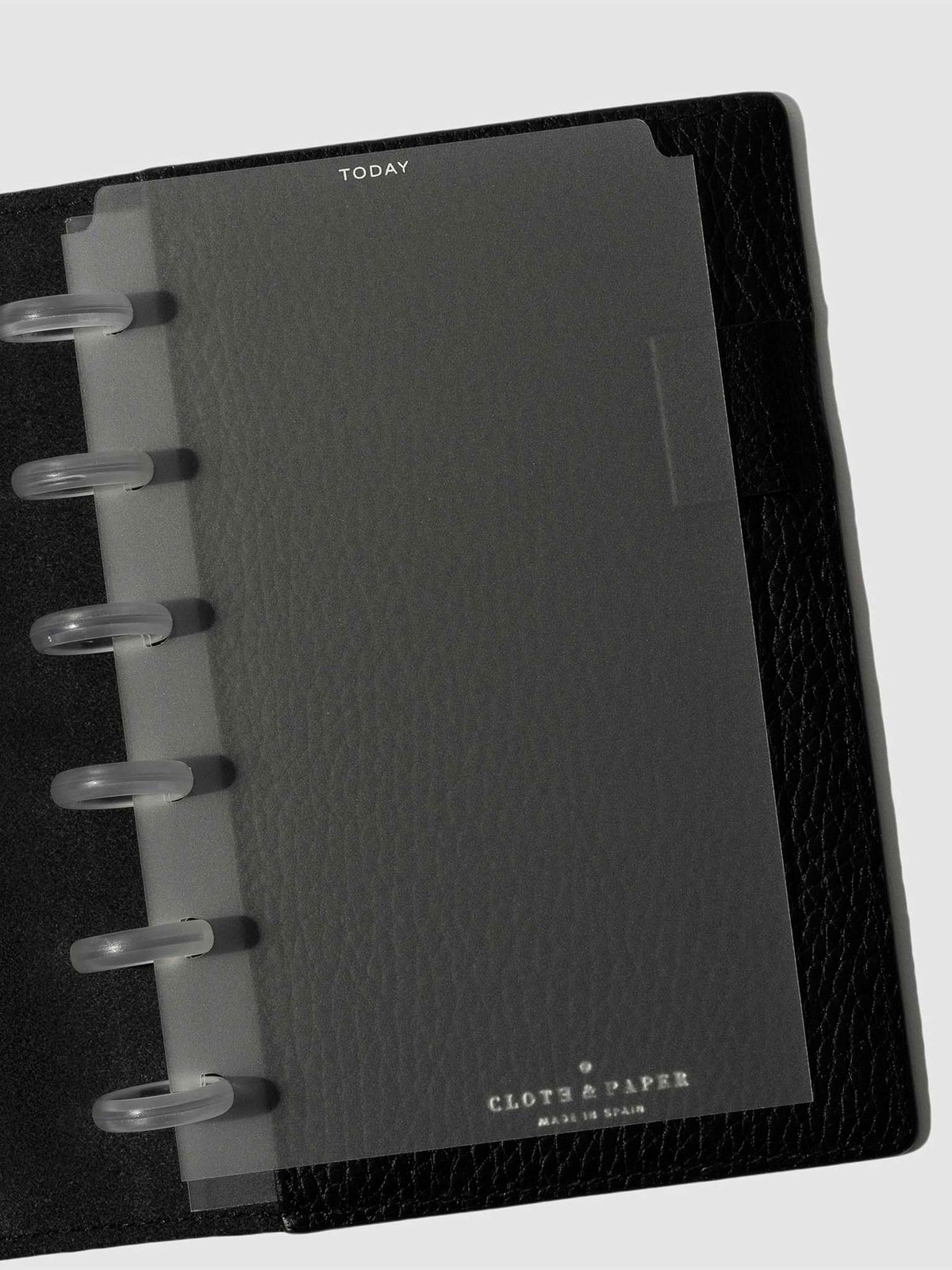 White foil divider displayed in a black leather planner.