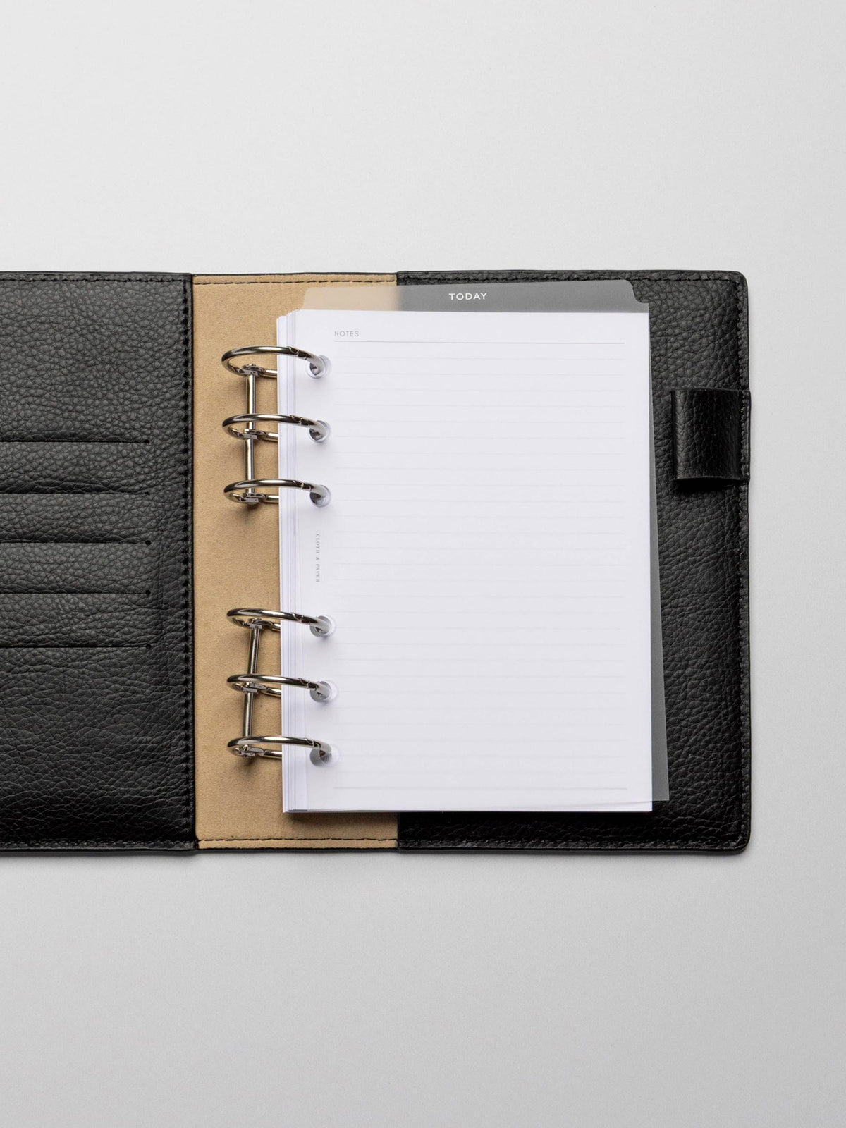 White foil divider displayed in a black leather planner.