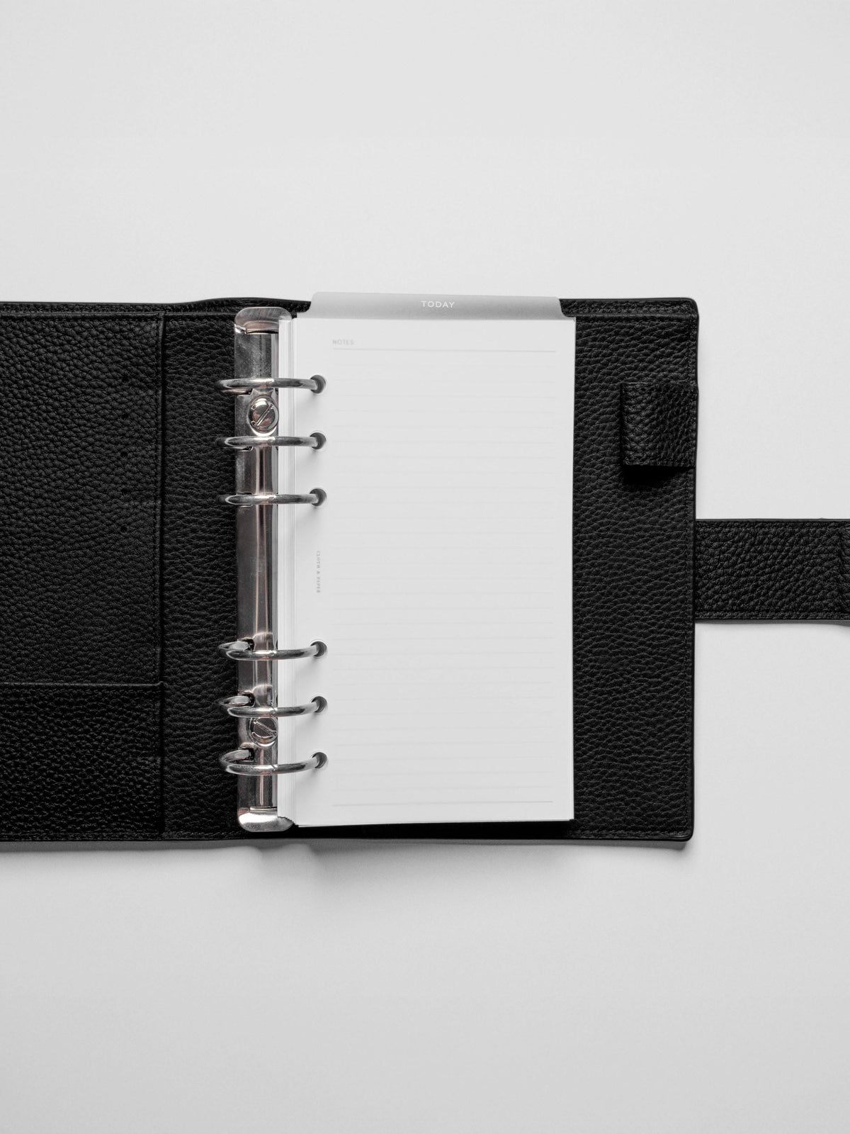 White foil divider displayed in a black leather planner.