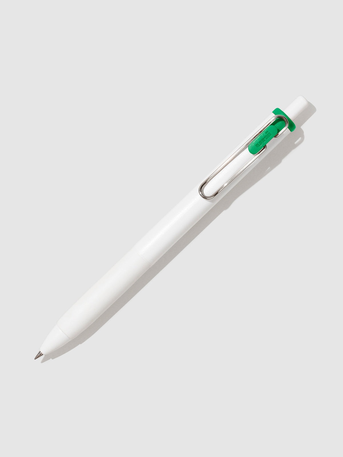 Uni-ball One Gel Pen, Palm Green, Cloth and Paper. Pen tilted slightly to the right on a neutral background.