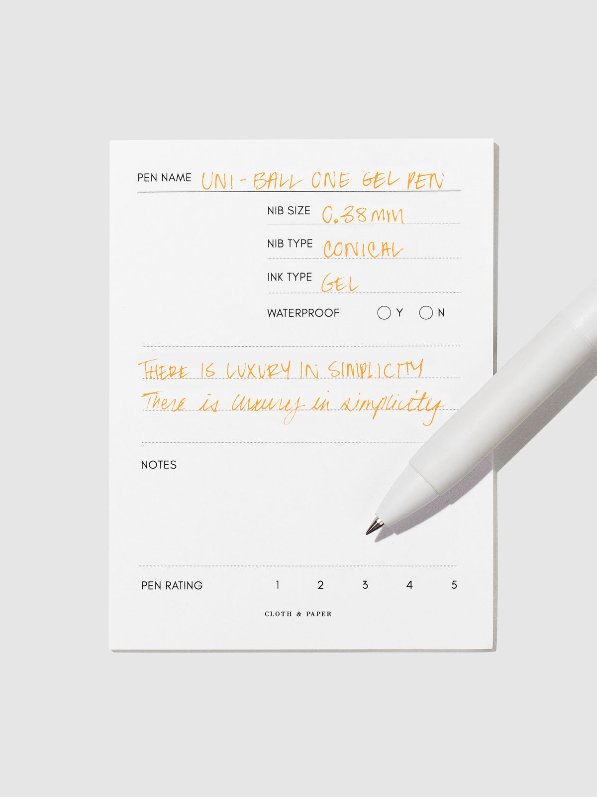 Pen tilted slightly to the right on a neutral background. Color pictured is Orange Cocktail.