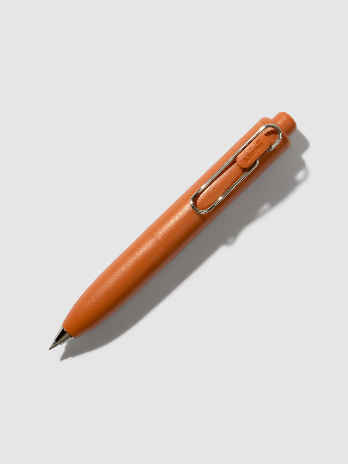 Uni-Ball One P Gel Pen, Cloth and Paper. Pen turned to the right on a neutral background. Color pictured is Mandarin Orange.