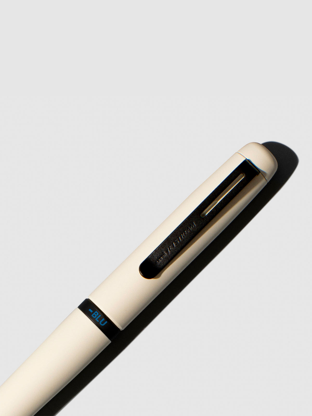 Pen shown close up, with the color selecting ring in focus. Pen ink color selected is blue, pen body is Cloudy White.