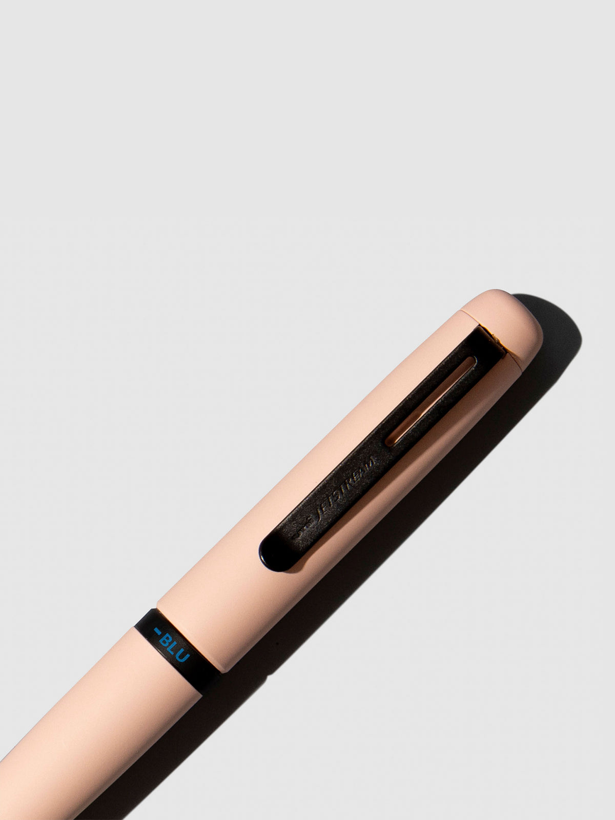 Pen shown close up, with the color selecting ring in focus. Pen ink color selected is blue, pen body is Cotton Pink.