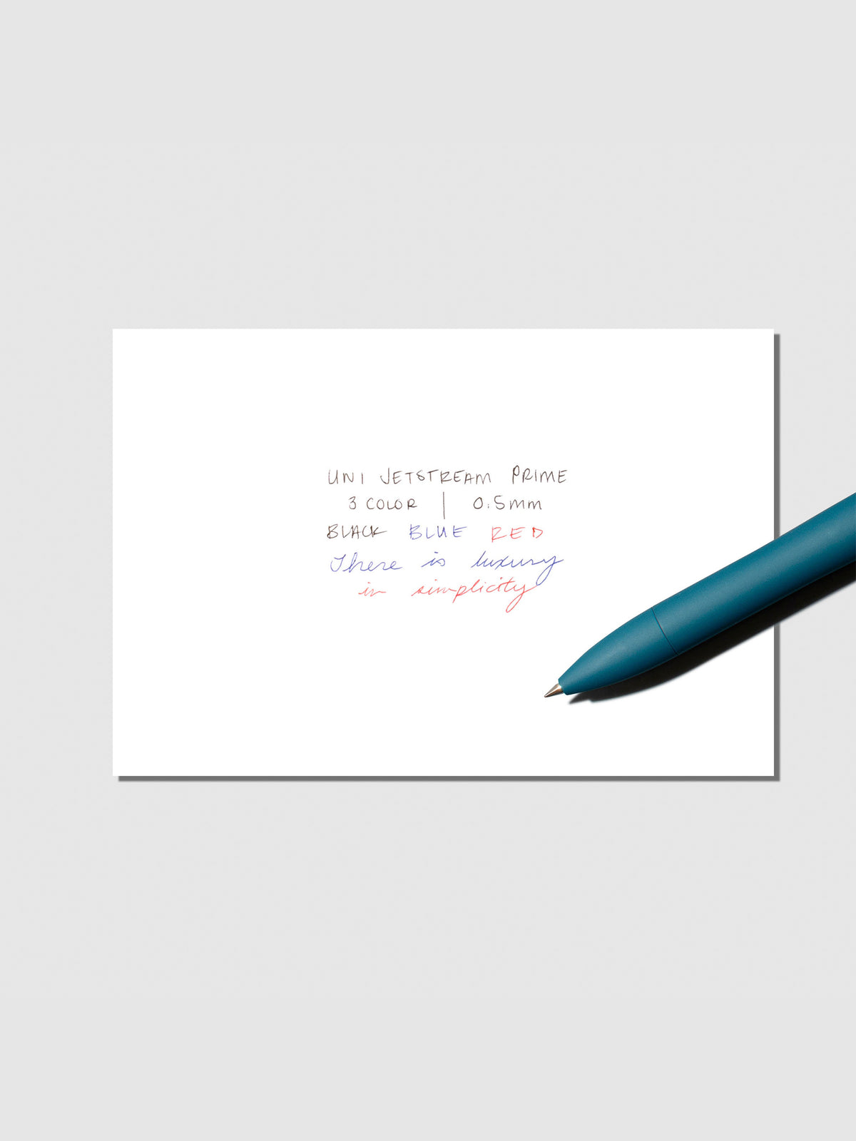 Writing sample with pen shown on a neutral background. Ink colors are black, red, and blue. Pen body color is Ivy Green.